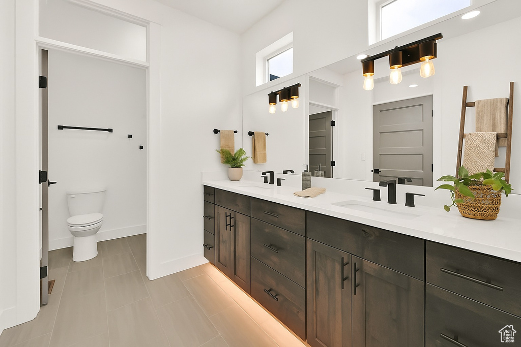 Bathroom featuring double vanity and baseboards