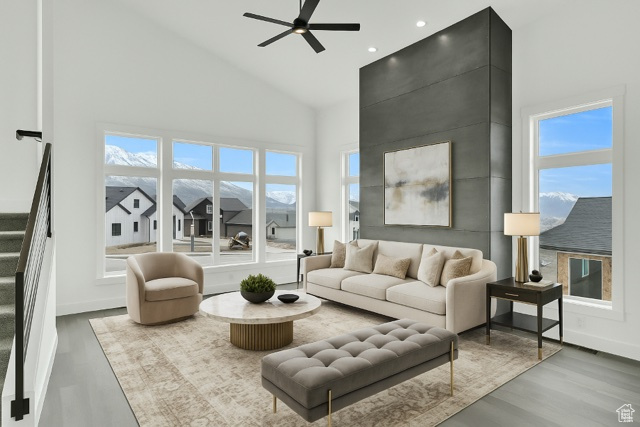Living room with high vaulted ceiling, ceiling fan, wood finished floors, plenty of natural light, and recessed lighting