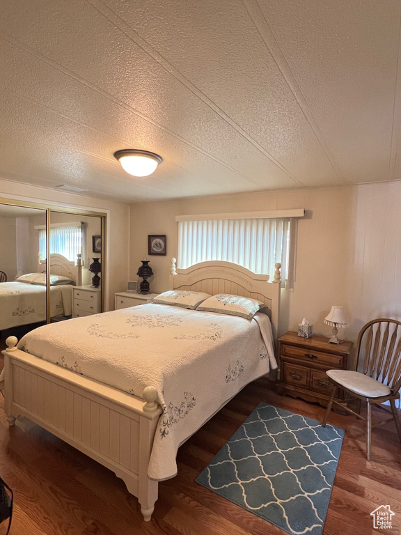 Bedroom featuring wood finished floors, a textured ceiling, and a closet