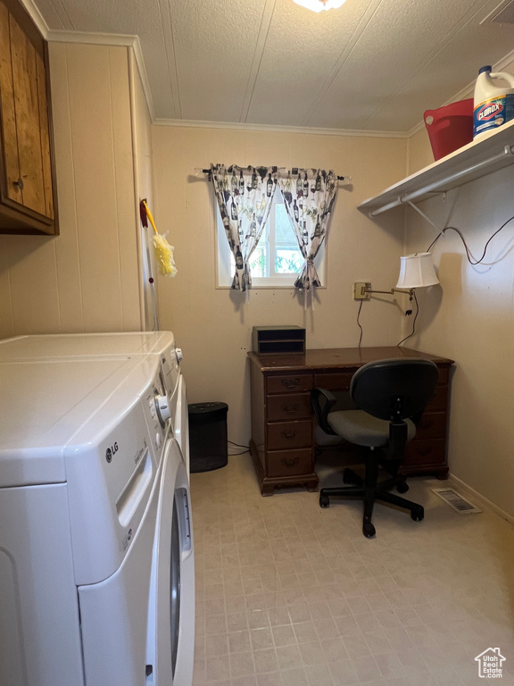Laundry area featuring washing machine and dryer, ornamental molding, cabinet space, light floors, and a textured ceiling