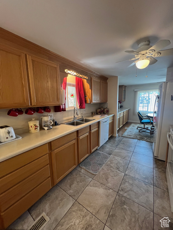 Kitchen featuring a sink, white appliances, light countertops, and ceiling fan