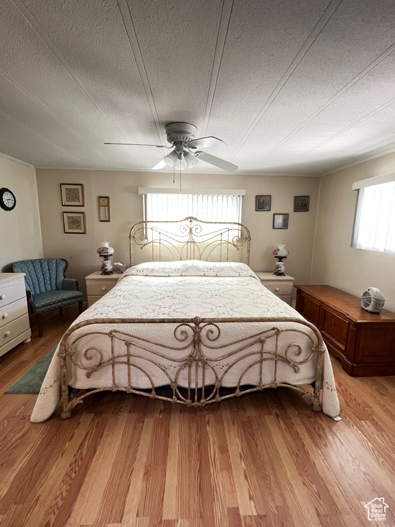 Bedroom featuring light wood-style flooring, a textured ceiling, and a ceiling fan