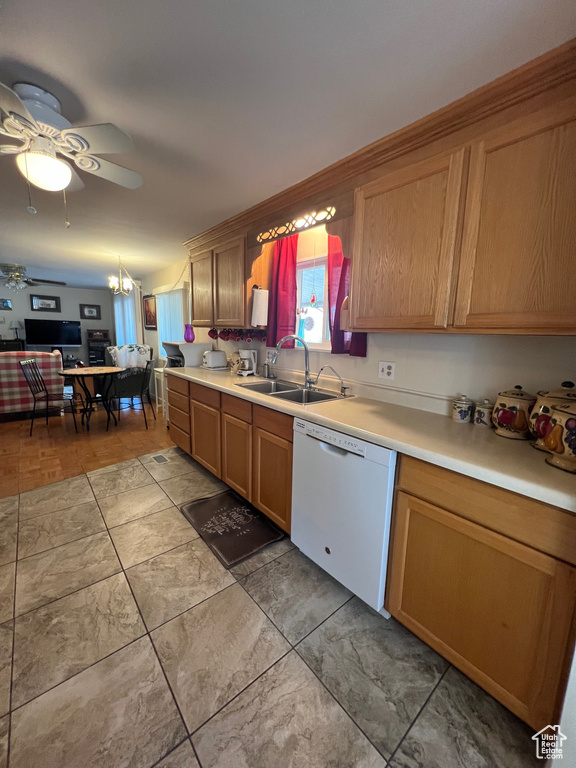 Kitchen featuring dishwasher, a sink, a ceiling fan, light countertops, and brown cabinetry