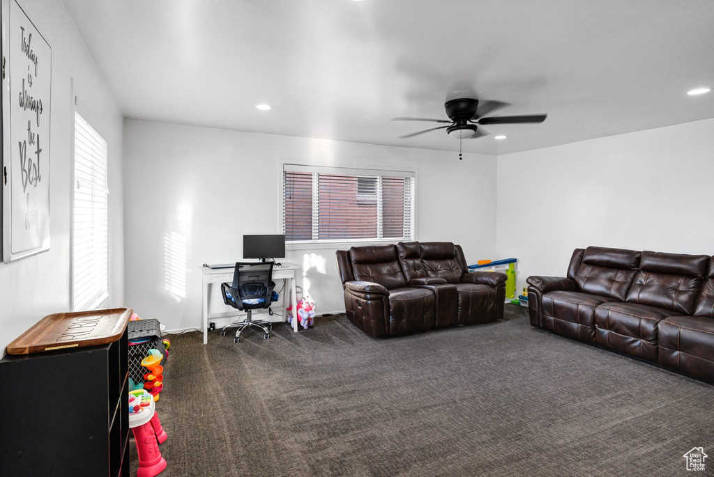 Living area featuring dark carpet, a ceiling fan, and recessed lighting