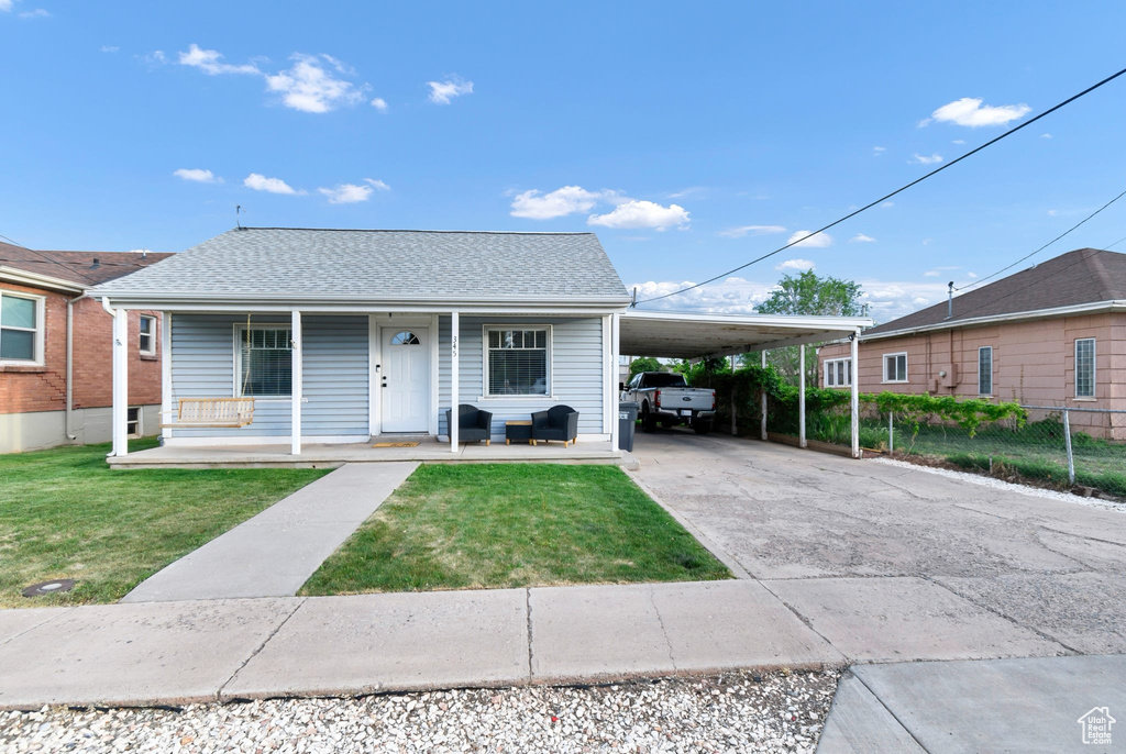 Bungalow-style house with concrete driveway, covered porch, and an attached carport