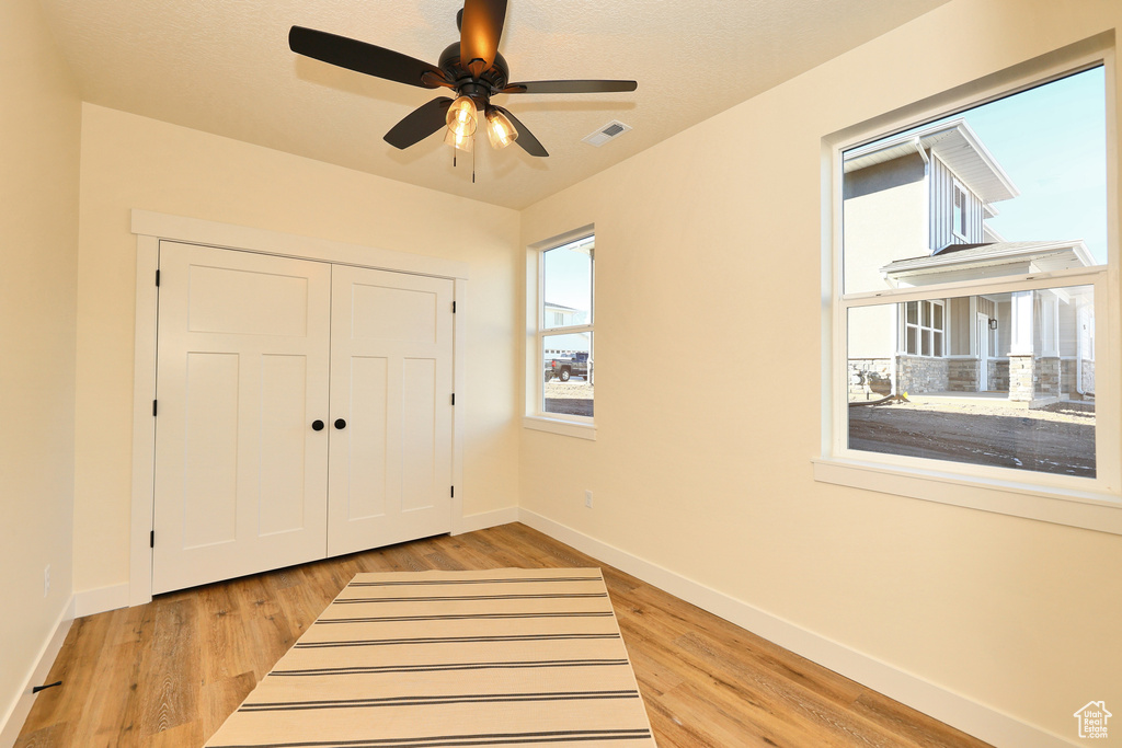 Unfurnished bedroom featuring baseboards, light wood-style flooring, a closet, and a ceiling fan