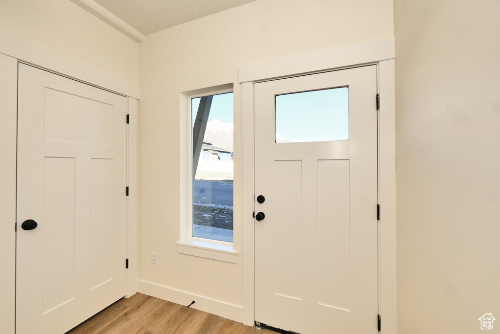Entryway with light wood-style flooring and baseboards