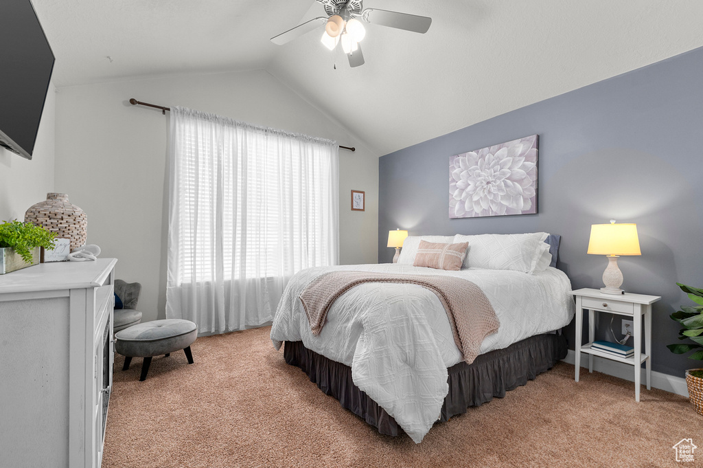 Bedroom featuring light colored carpet, lofted ceiling, and a ceiling fan