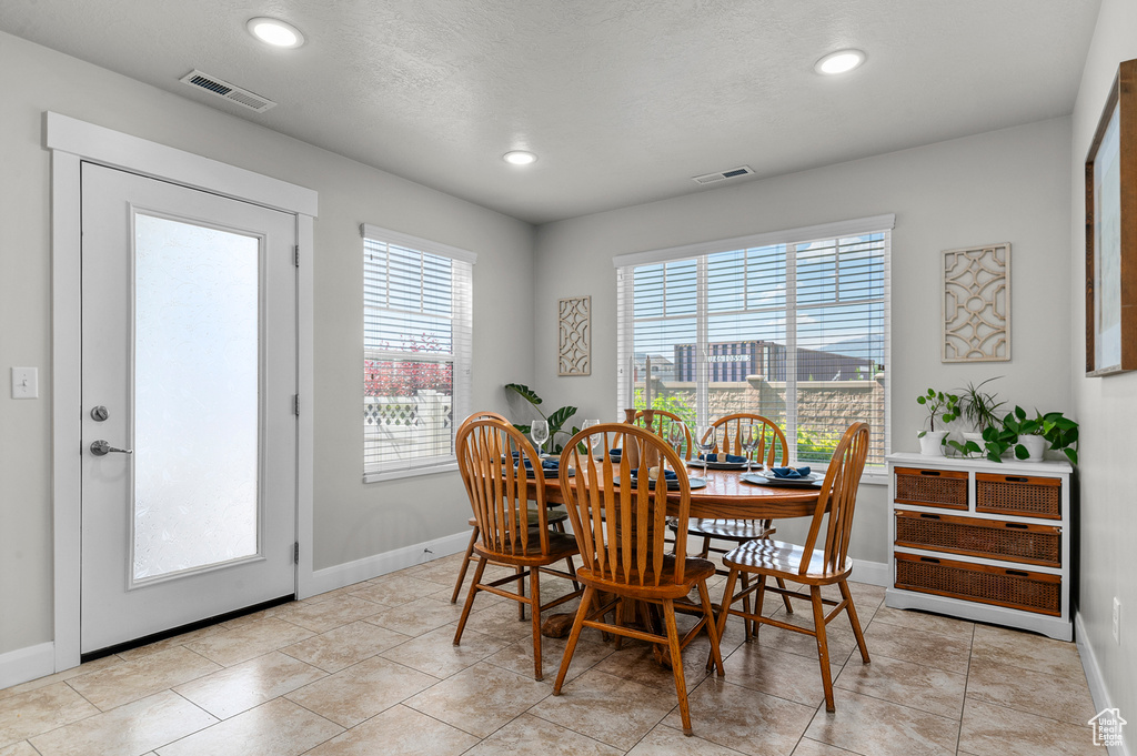 Dining space with recessed lighting, baseboards, and light tile patterned floors