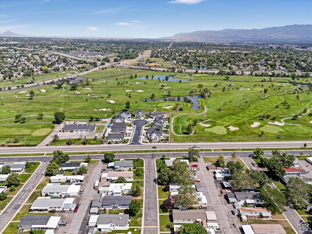 Aerial overview of property's location with a water and mountain view, a golf course, and nearby suburban area