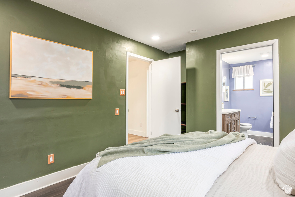 Bedroom featuring wood finished floors, baseboards, recessed lighting, and ensuite bath