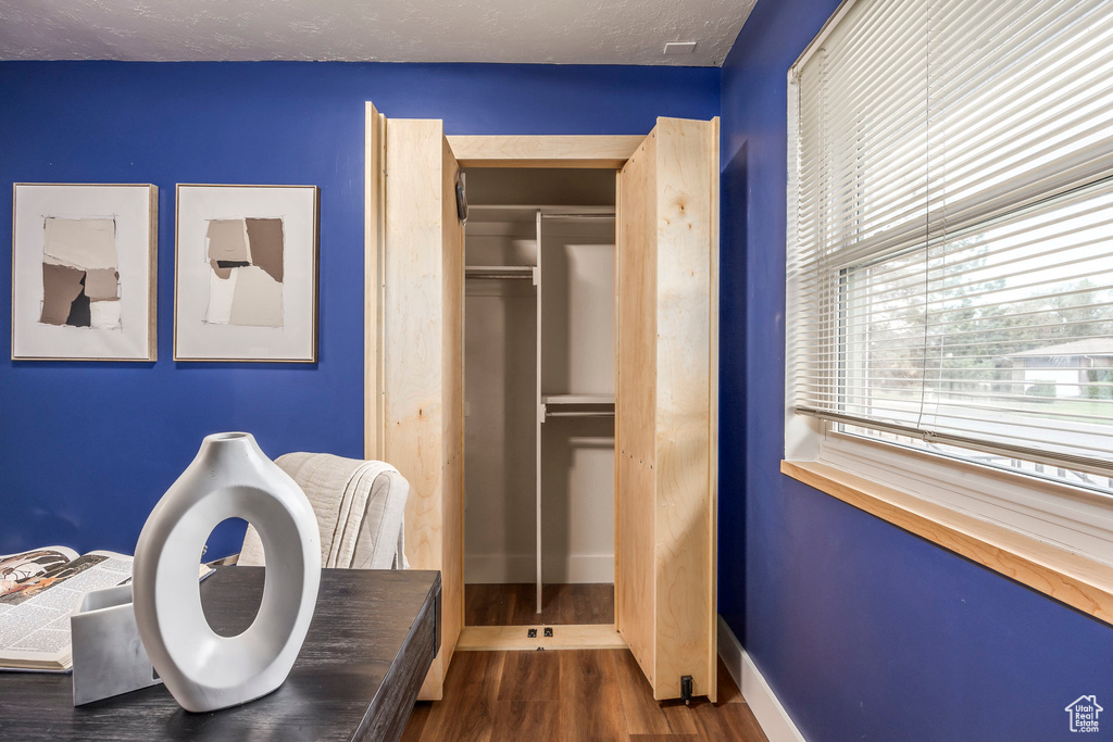 Bedroom with wood finished floors, baseboards, and a closet