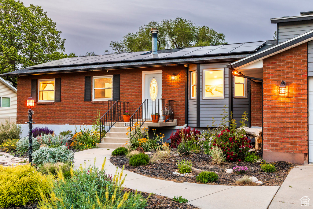 View of front of home with brick siding and solar panels