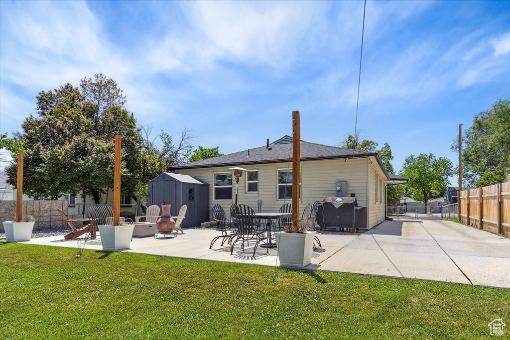 Back of house with an outdoor fire pit and a patio