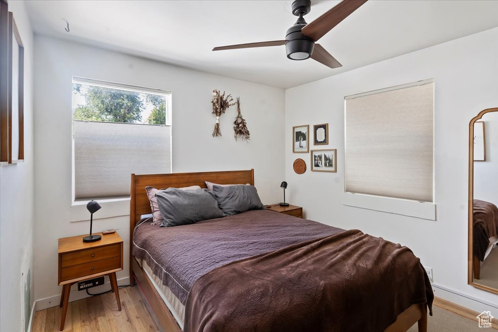 Bedroom with light wood-style floors, a ceiling fan, and baseboards