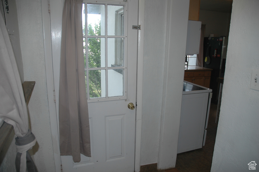 Entryway with healthy amount of natural light and dark tile patterned floors