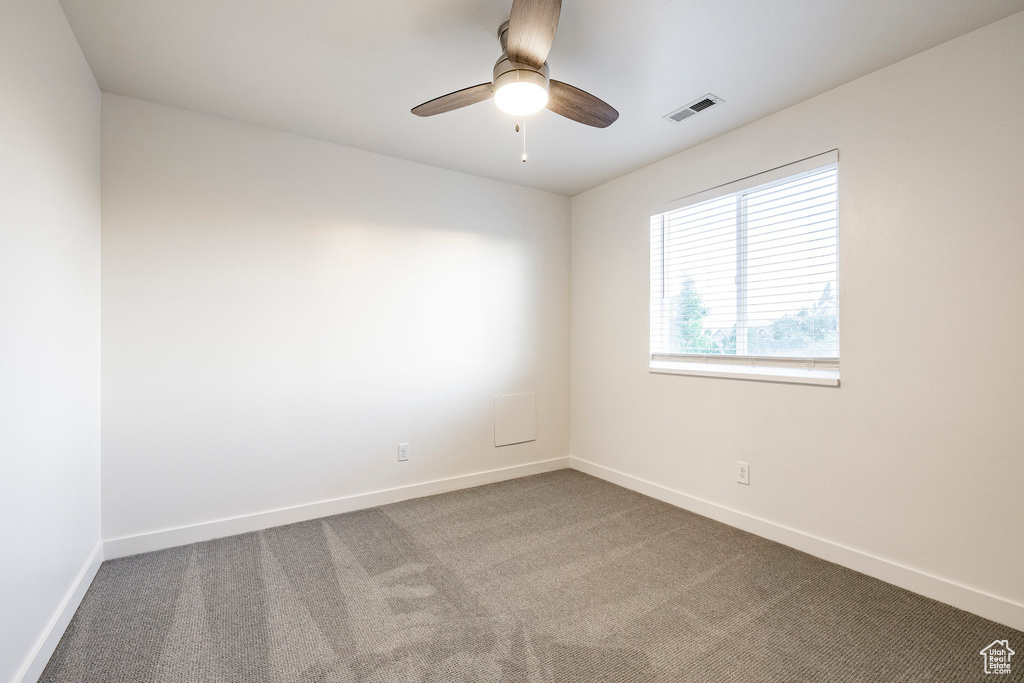 Unfurnished room with carpet floors, baseboards, and ceiling fan