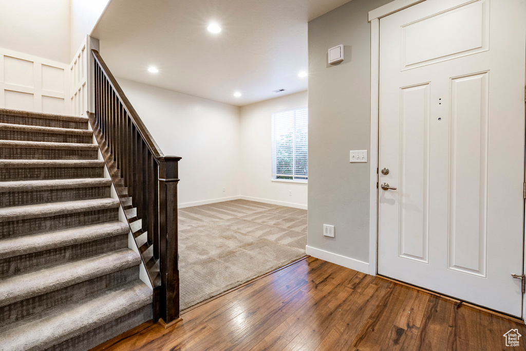 Foyer featuring stairway, hardwood / wood-style flooring, recessed lighting, and baseboards
