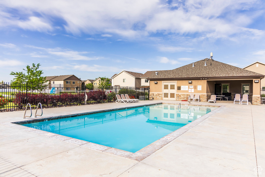 Community pool with a patio and a residential view