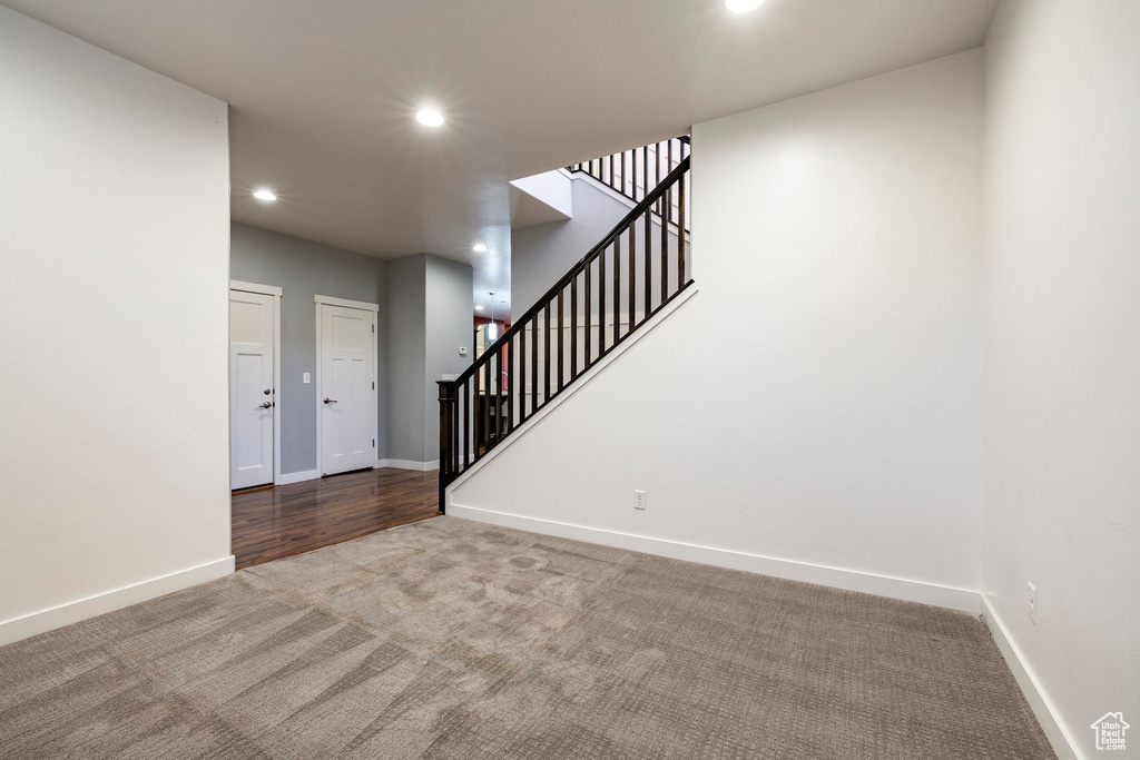 Carpeted entrance foyer featuring recessed lighting, stairway, and baseboards