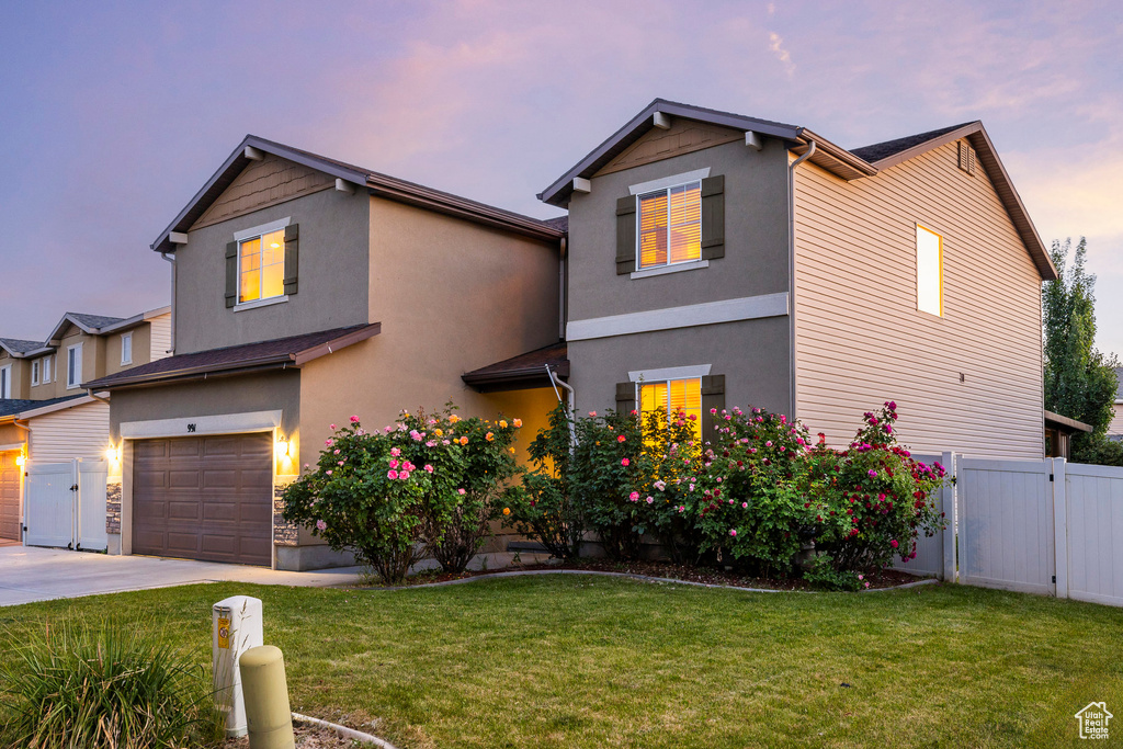 Traditional-style home with a garage, concrete driveway, stucco siding, and a gate