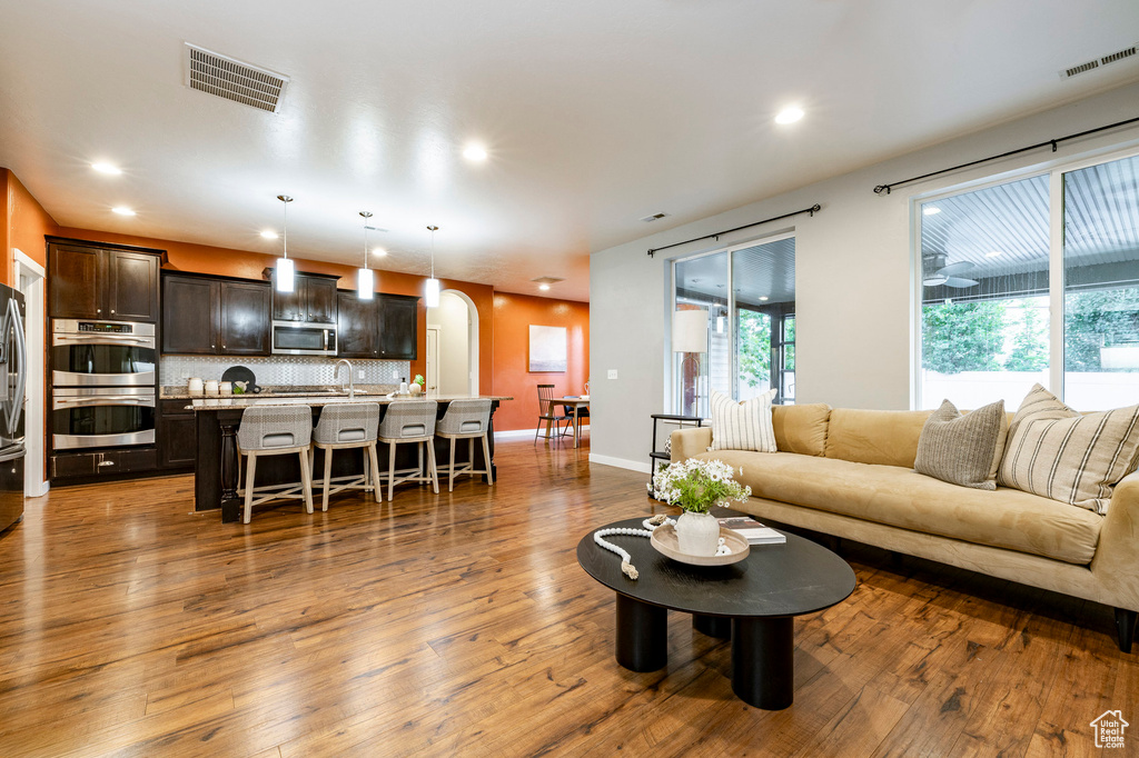 Living area with hardwood / wood-style floors, plenty of natural light, recessed lighting, and baseboards