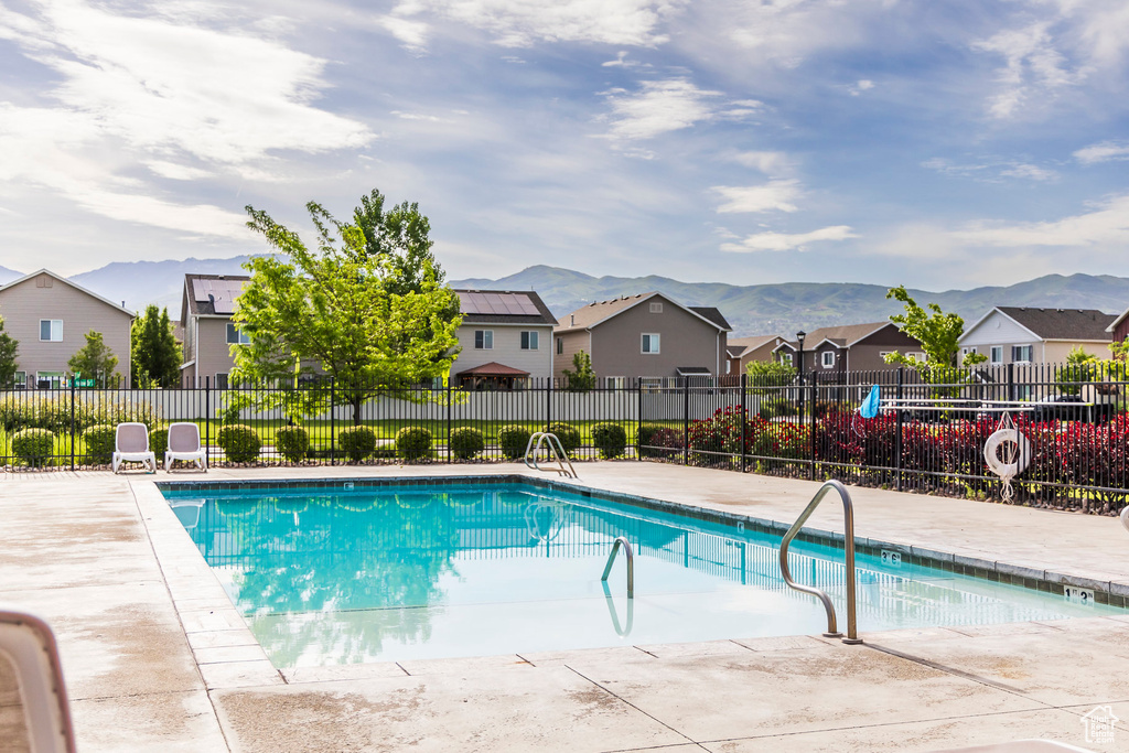 Community pool with a residential view, a mountain view, and a patio area