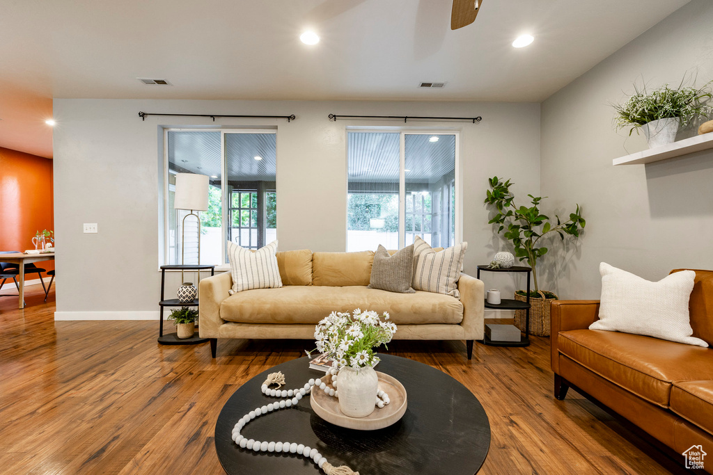 Living room with wood finished floors, a ceiling fan, recessed lighting, and baseboards