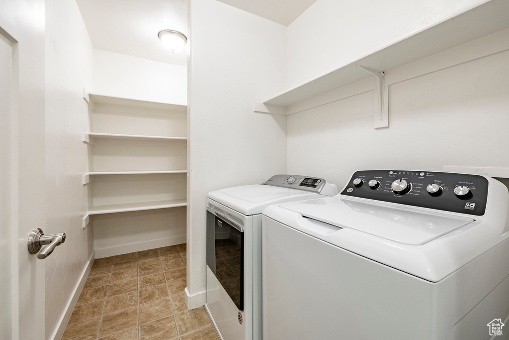Washroom with washing machine and dryer and baseboards