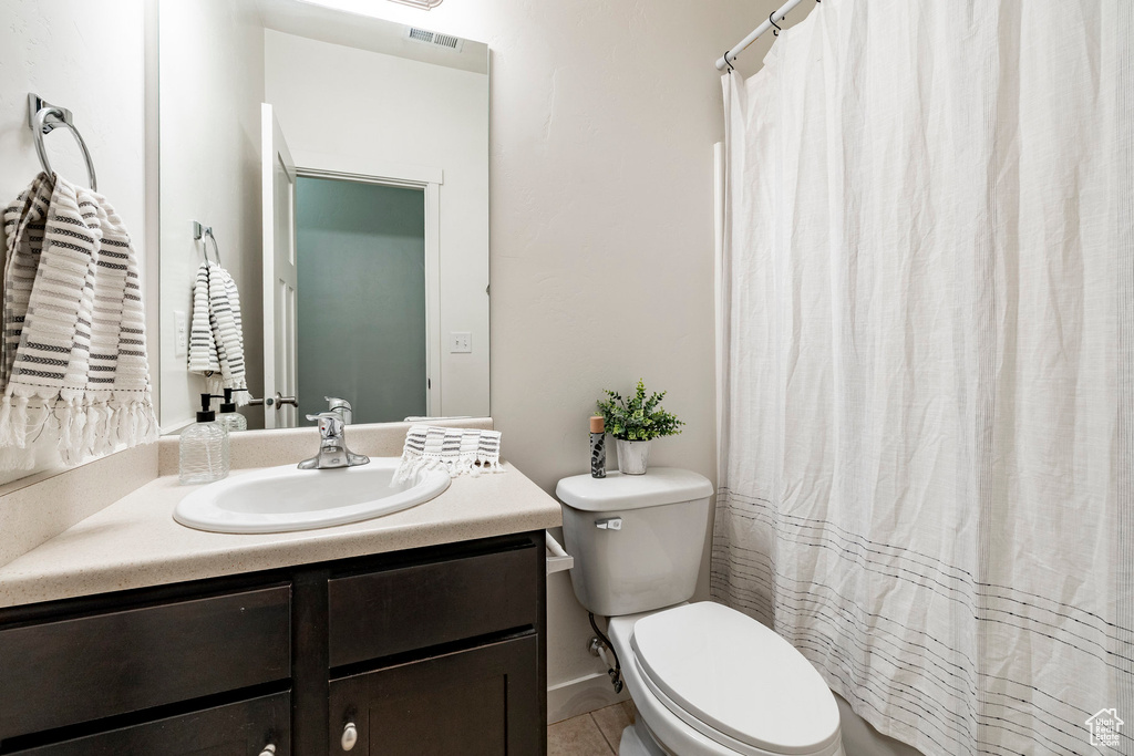 Full bath with vanity, toilet, tile patterned floors, and a shower with shower curtain