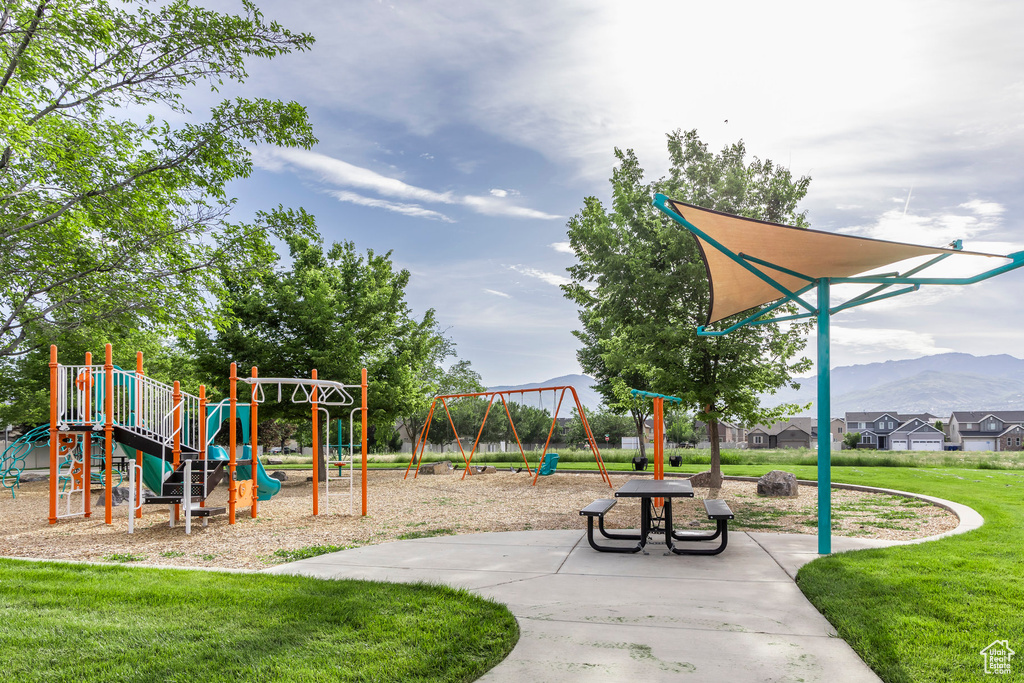 Communal playground with a yard and a mountain view