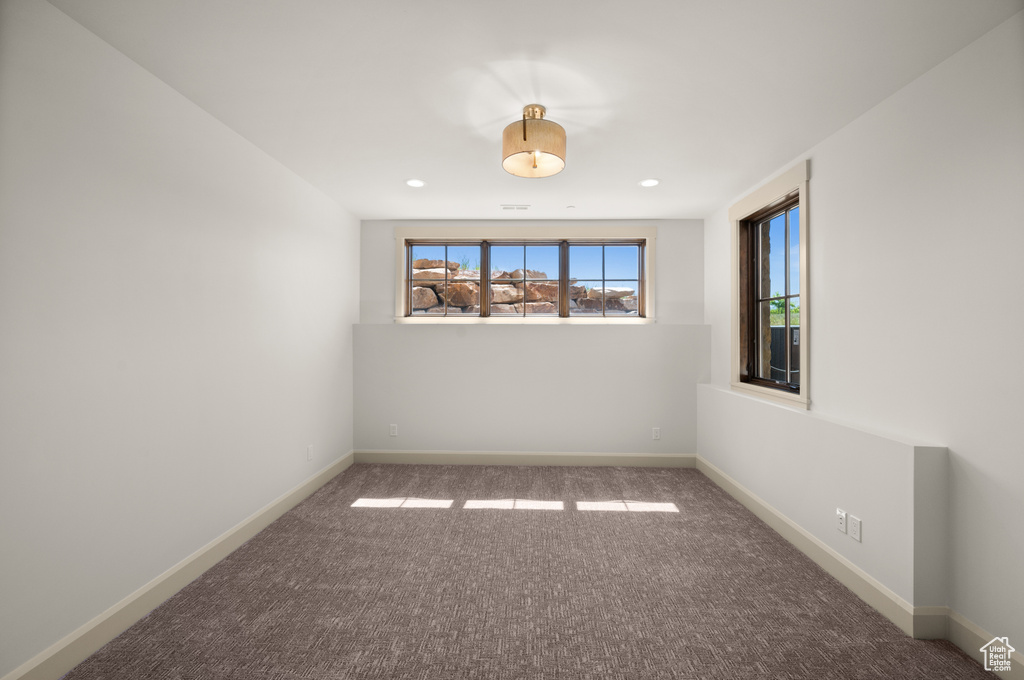 Carpeted spare room featuring baseboards