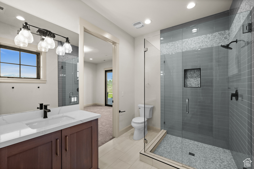 Bathroom featuring vanity, a stall shower, toilet, recessed lighting, and baseboards