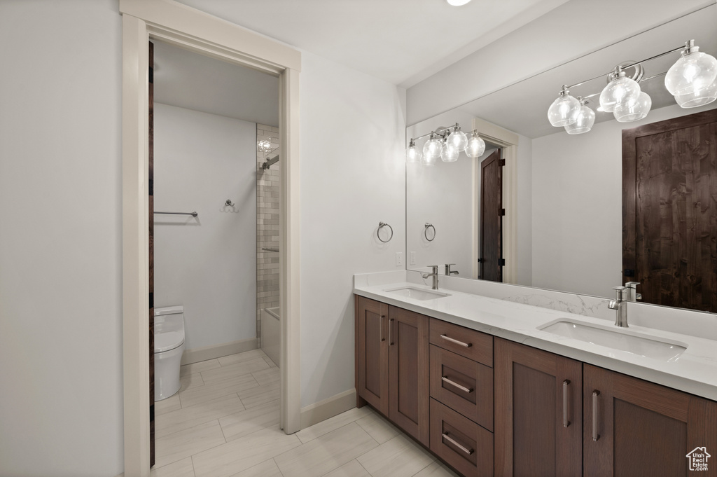 Full bathroom with double vanity, toilet, and shower / bath combination