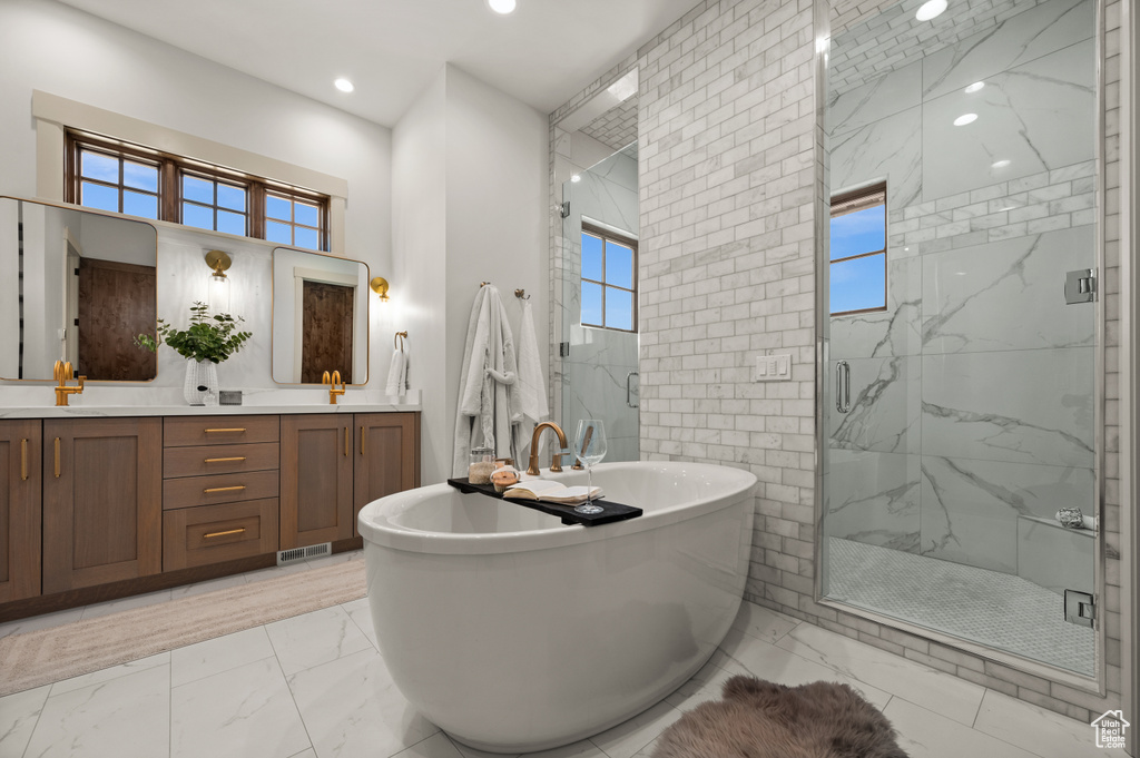 Full bathroom with marble finish flooring, a marble finish shower, recessed lighting, double vanity, and a freestanding bath