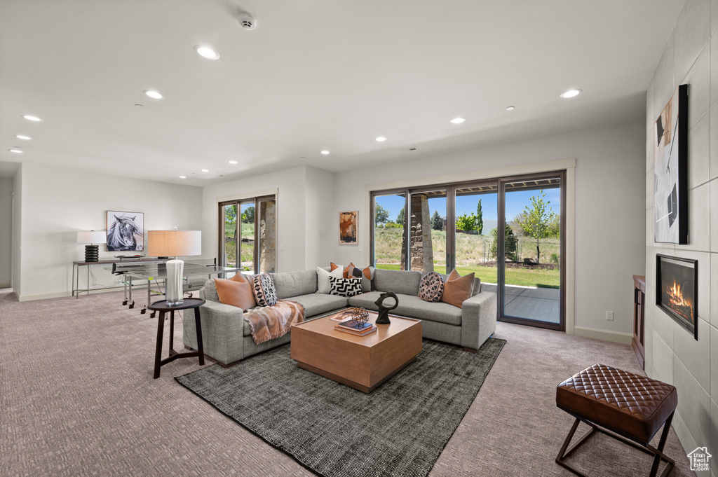 Living area with recessed lighting, carpet flooring, a fireplace, and baseboards