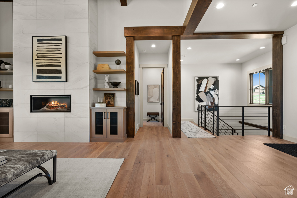 Living room with wood finished floors, a fireplace, and recessed lighting