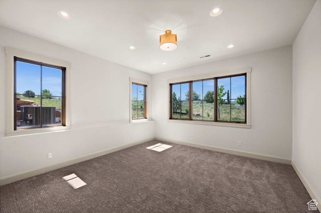 Carpeted empty room with healthy amount of natural light, recessed lighting, and baseboards