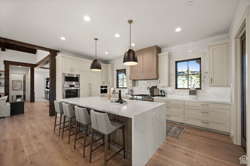 Kitchen with appliances with stainless steel finishes, decorative backsplash, plenty of natural light, a kitchen breakfast bar, and recessed lighting
