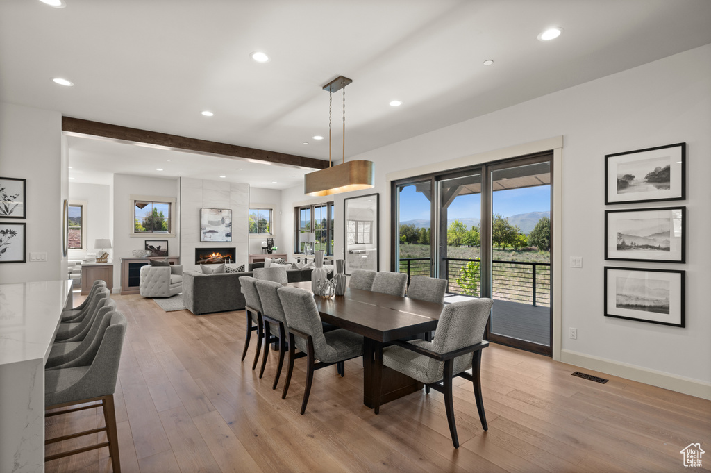 Dining space with recessed lighting, light wood-style floors, a large fireplace, and baseboards