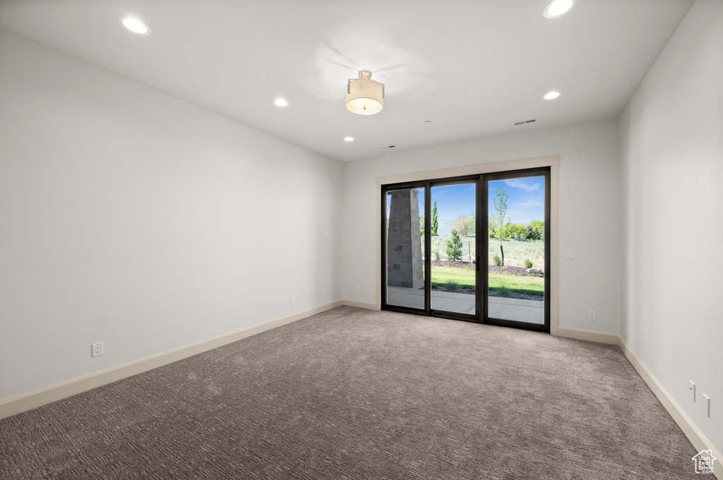 Empty room featuring recessed lighting, light carpet, and baseboards