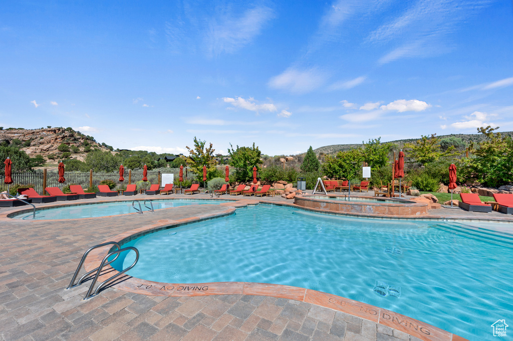 Community pool with a patio area and a mountain view