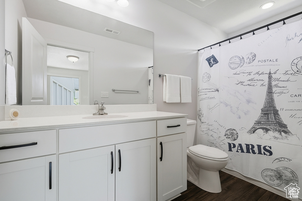 Full bathroom with vanity, wood finished floors, and curtained shower
