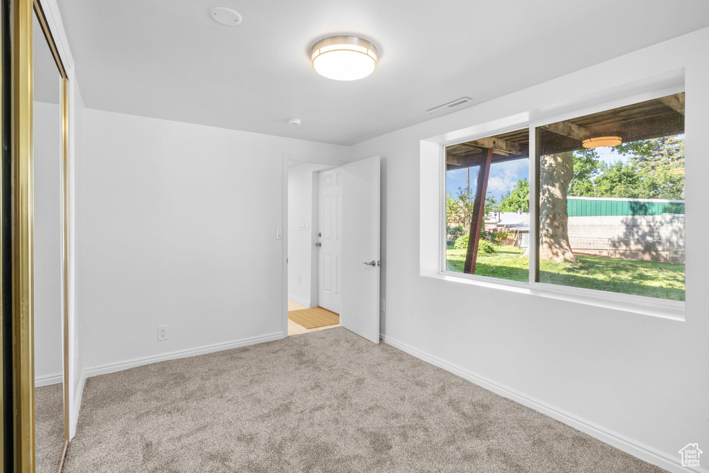 Unfurnished bedroom with carpet flooring and baseboards