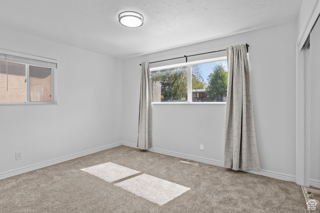 Unfurnished room featuring carpet floors and baseboards