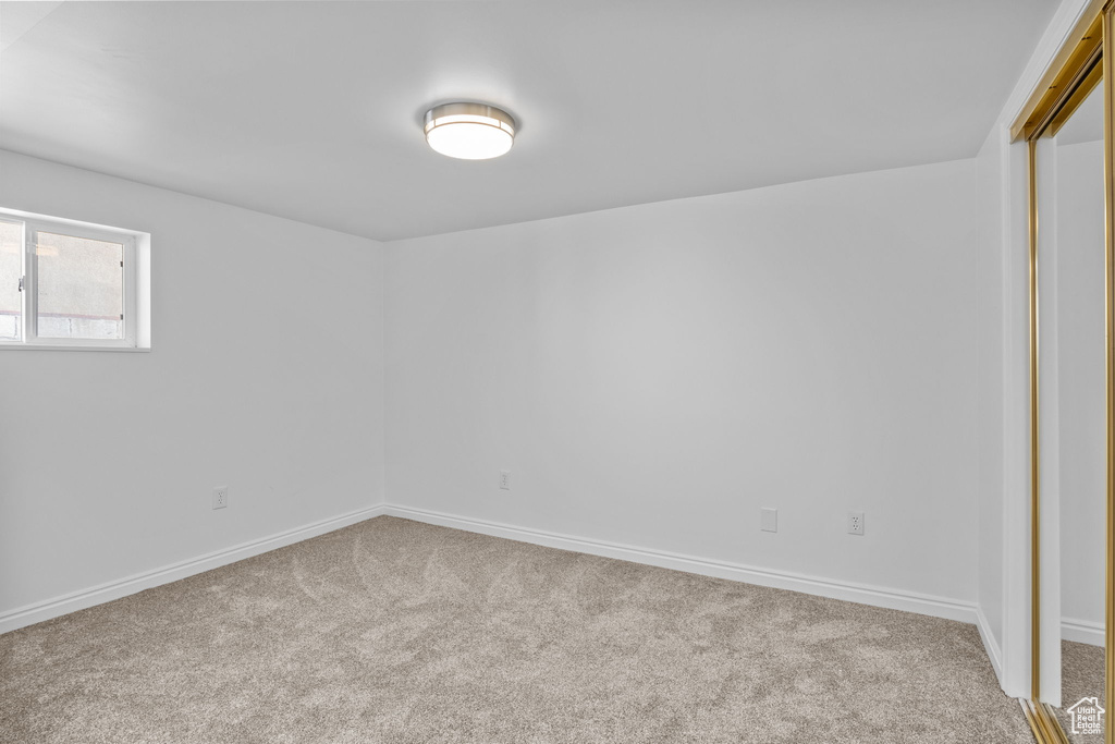 Carpeted empty room featuring baseboards