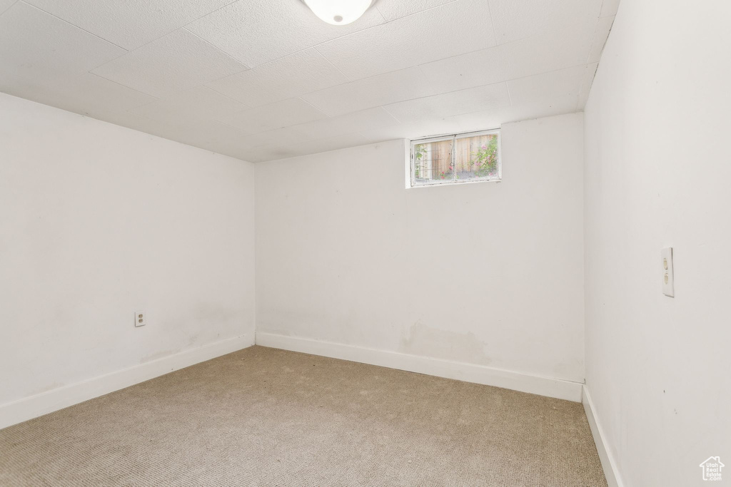 Basement with light carpet and baseboards