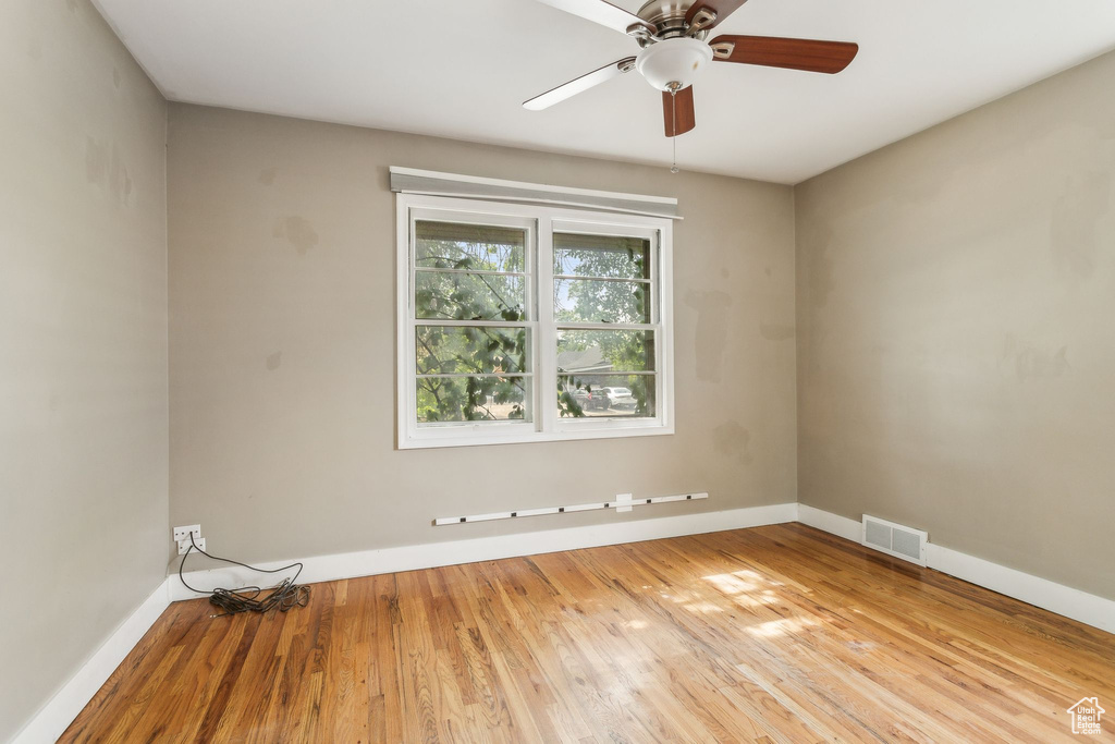 Spare room with baseboards, hardwood / wood-style flooring, and a ceiling fan