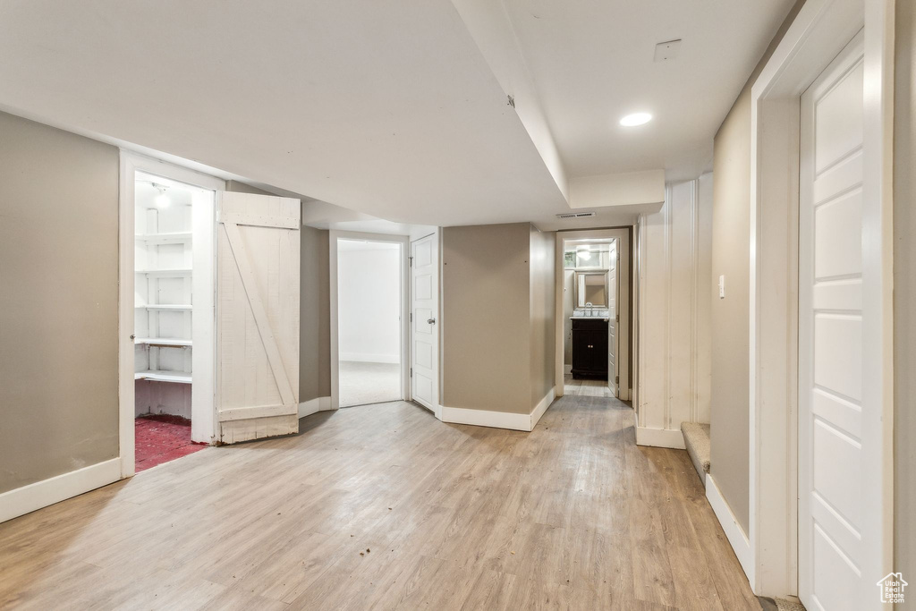 Finished below grade area featuring light wood-type flooring and baseboards