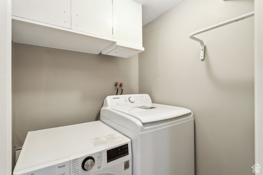Washroom featuring cabinet space and washer and dryer